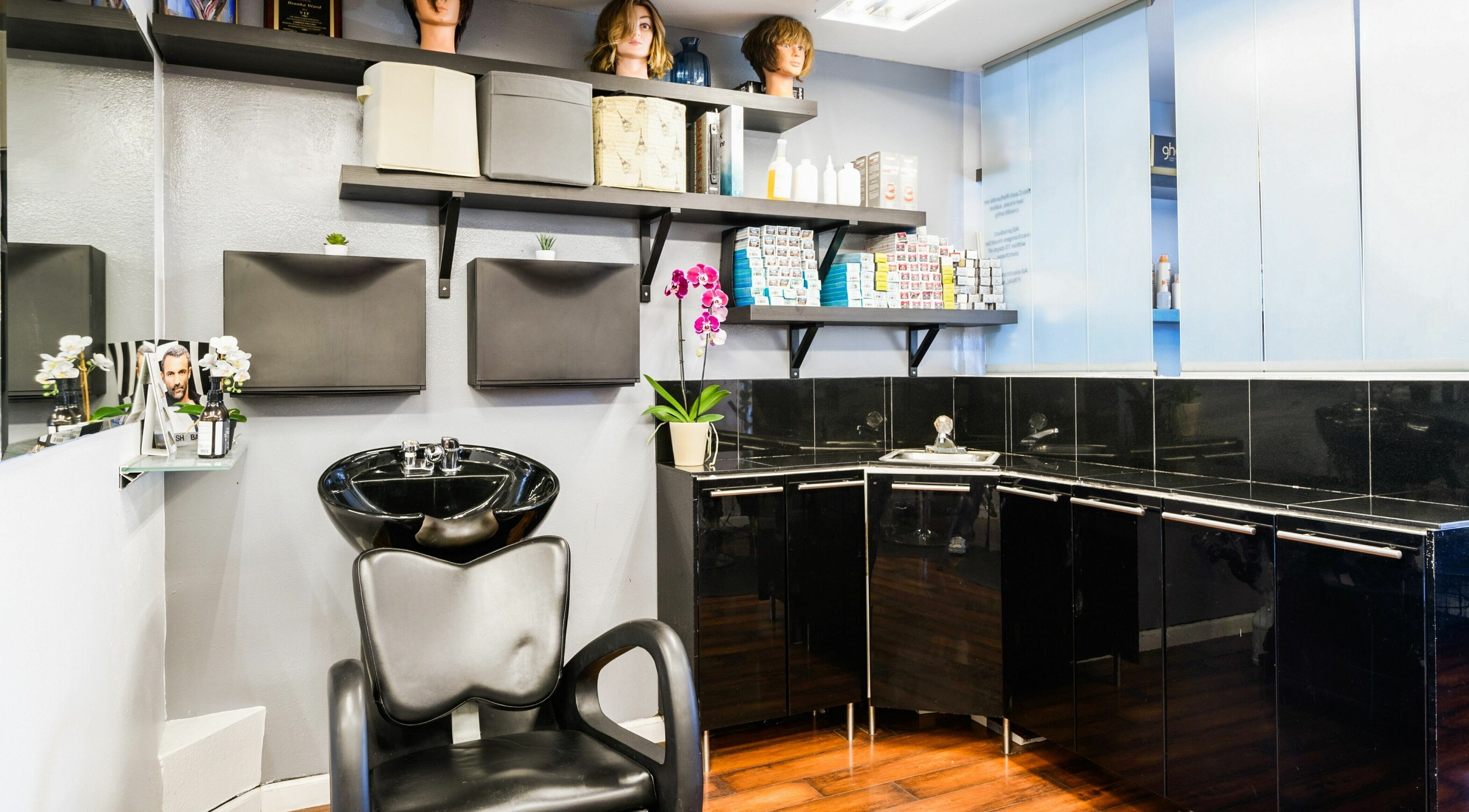 Modern wash station at Mud Honey Salon, Manhattan Beach, California, US. Sleek design with storage and orchid decor.