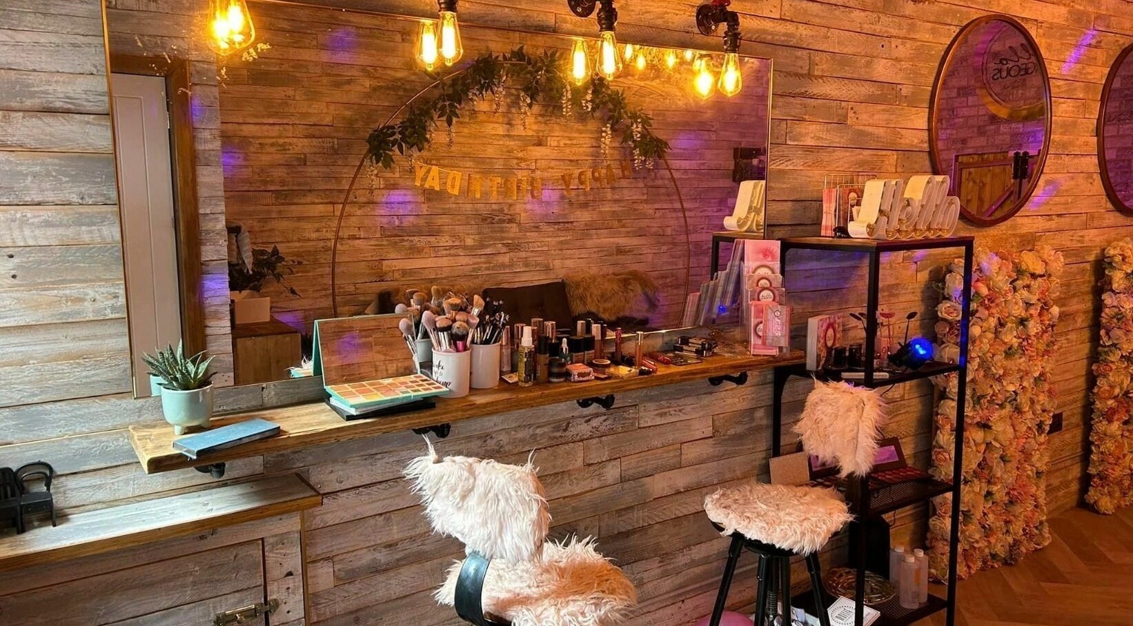 Cozy makeup area with fluffy chairs at Lash & Co, Fleetwood, England, GB. Warm lighting and decorative touches.