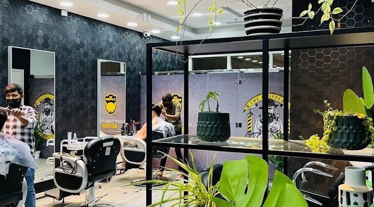 Interior of The Clippers, Cluster Q, JLT in Dubai featuring modern barber chairs and lush plants.