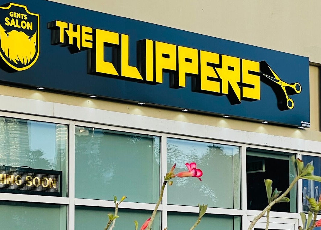The Clippers, Cluster Q, JLT salon sign in Dubai, Dubai, AE with vibrant flowers in front.