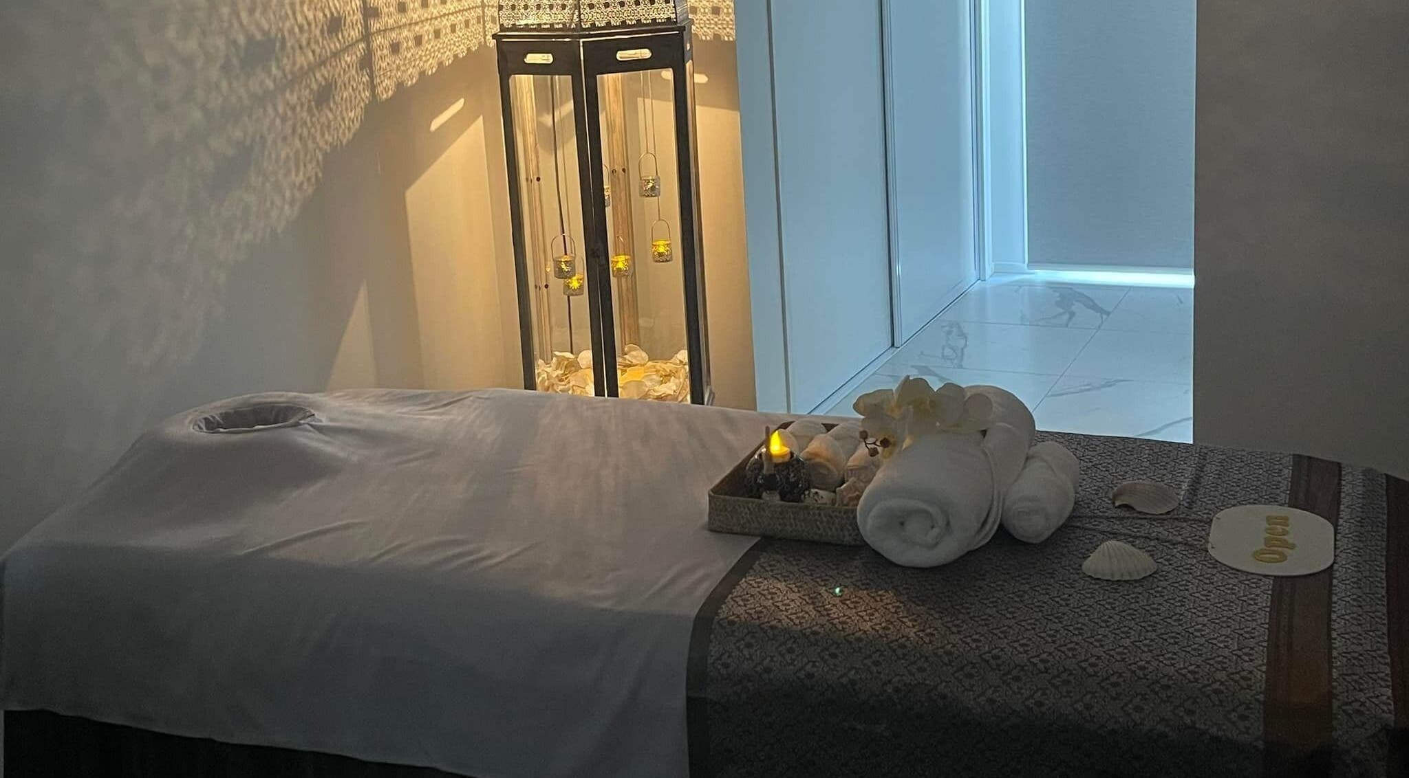 Tranquil massage room at Wai Thai Riccarton, Massage Clinic in Christchurch, NZ. Illuminated ambiance with towels and decor.