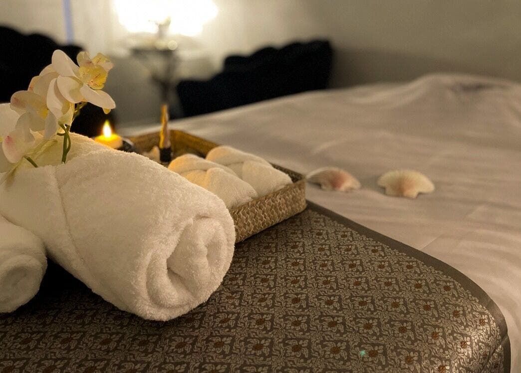 Relaxing setup at Wai Thai New Brighton Massage Clinic, Christchurch, with towels and orchids.