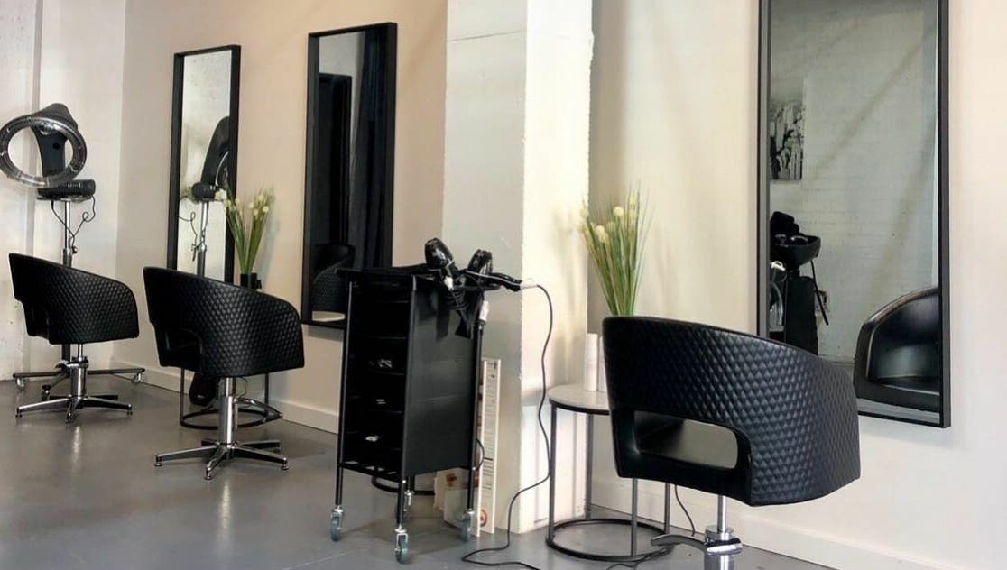 Modern salon setup at Laura and Co Hairdressing, Rozelle, New South Wales, AU, showcasing stylish black chairs.