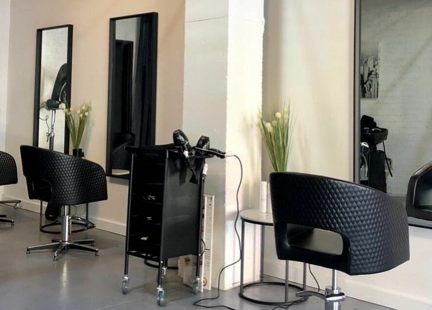 Modern salon setup at Laura and Co Hairdressing, Rozelle, New South Wales, AU, showcasing stylish black chairs.