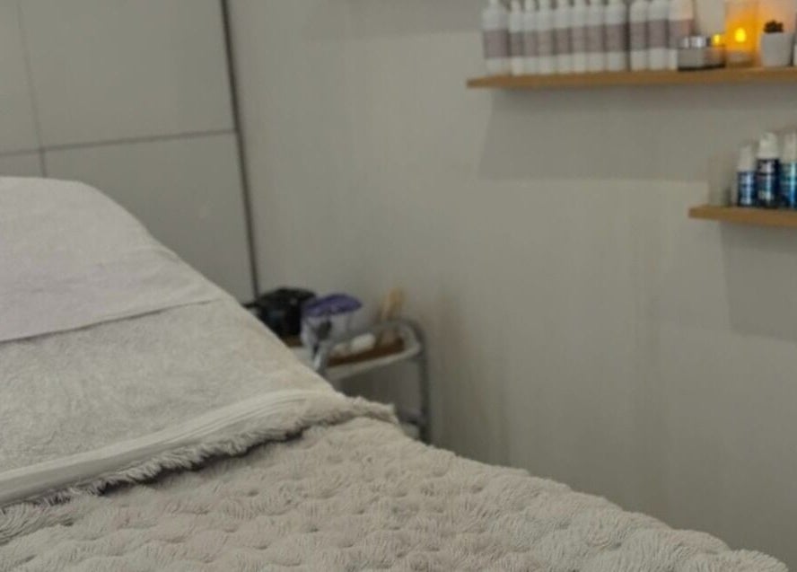 Calming treatment room at Chic in Preston, England, GB with cozy bedding and skincare products on shelves.