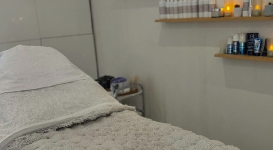 Calming treatment room at Chic in Preston, England, GB with cozy bedding and skincare products on shelves.