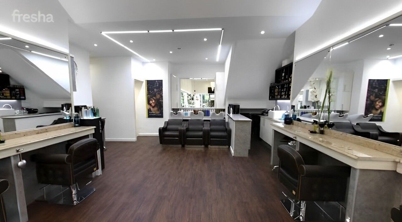 Modern interior of Design A Head Tunbridge Wells salon in Tunbridge Wells, England, featuring sleek chairs and mirrors.