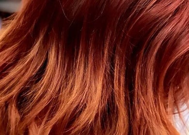 Vibrant red hair styled at Roxstar Hair Design, Punta Gorda, Florida, US, showcasing rich color and shine.