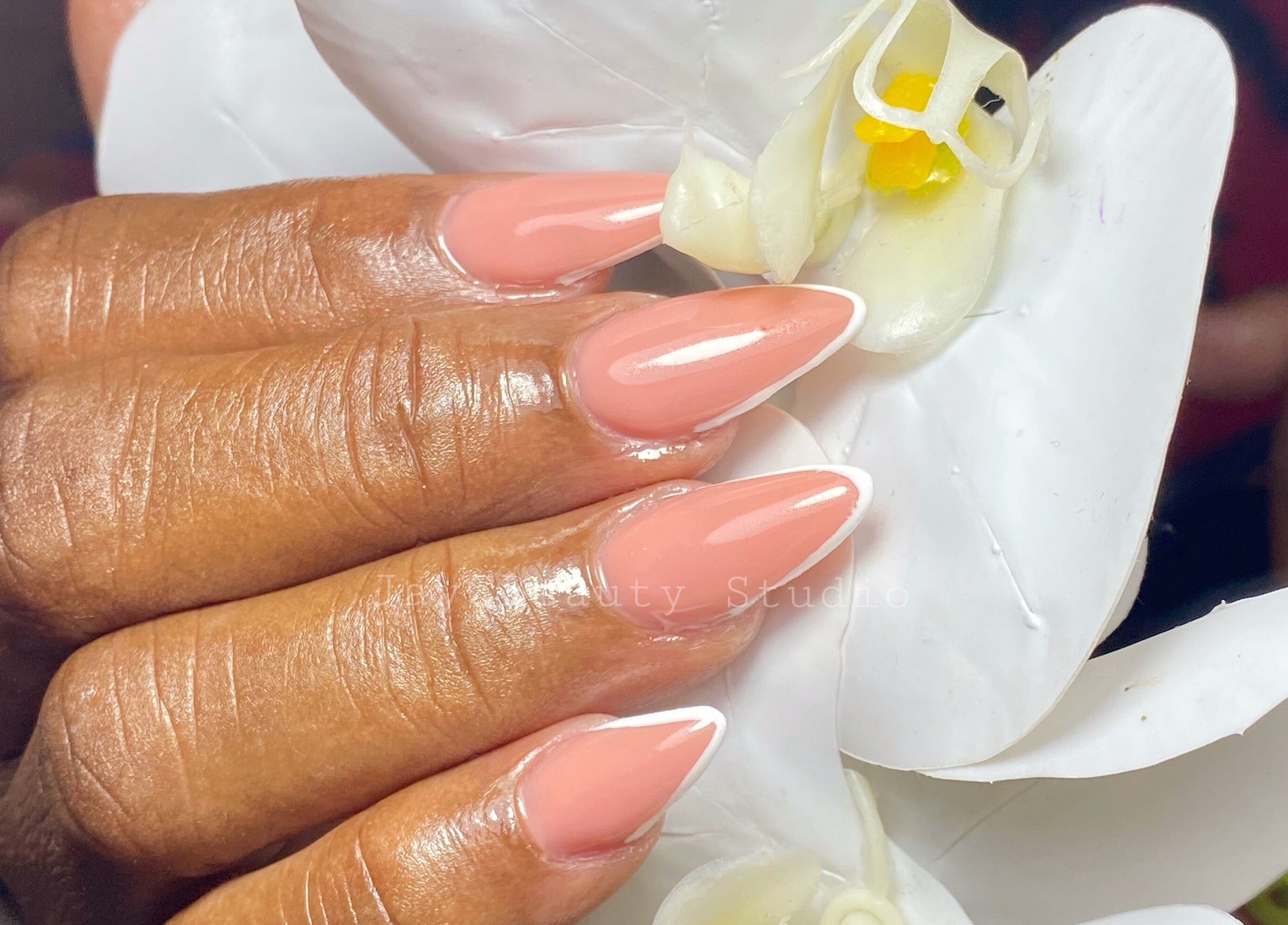 Elegant manicure at JayC Beauty Studio, Bridgetown, Christ Church. Glossy nails with a flower backdrop.