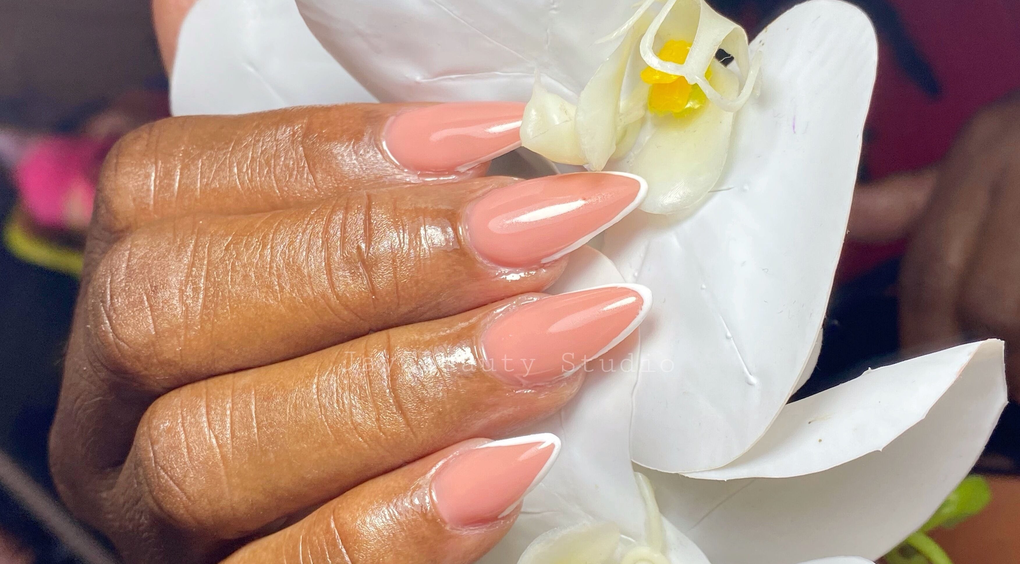 Elegant manicure at JayC Beauty Studio, Bridgetown, Christ Church. Glossy nails with a flower backdrop.