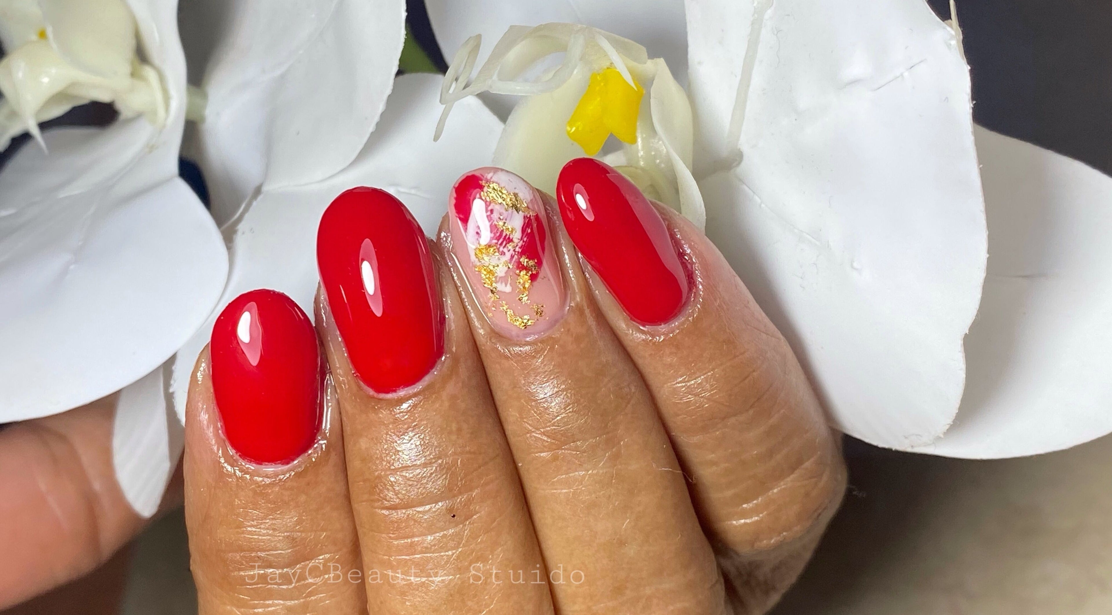 Red manicured nails with gold accents at JayC Beauty Studio, Bridgetown, Christ Church, BB.