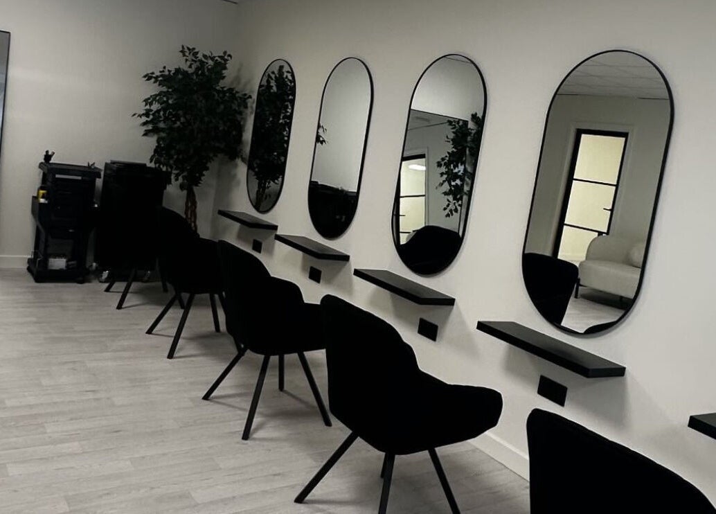 Modern salon interior at Thesachhouse in Wigan, England, GB, featuring stylish black chairs and mirrors.