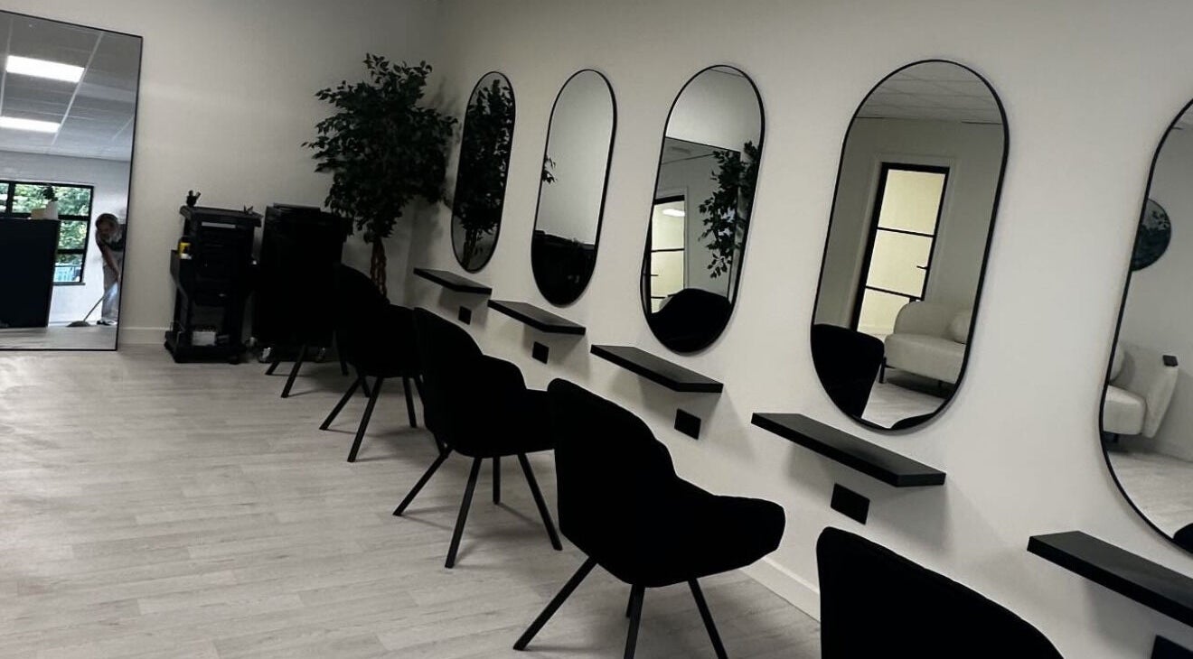 Modern salon interior at Thesachhouse in Wigan, England, GB, featuring stylish black chairs and mirrors.