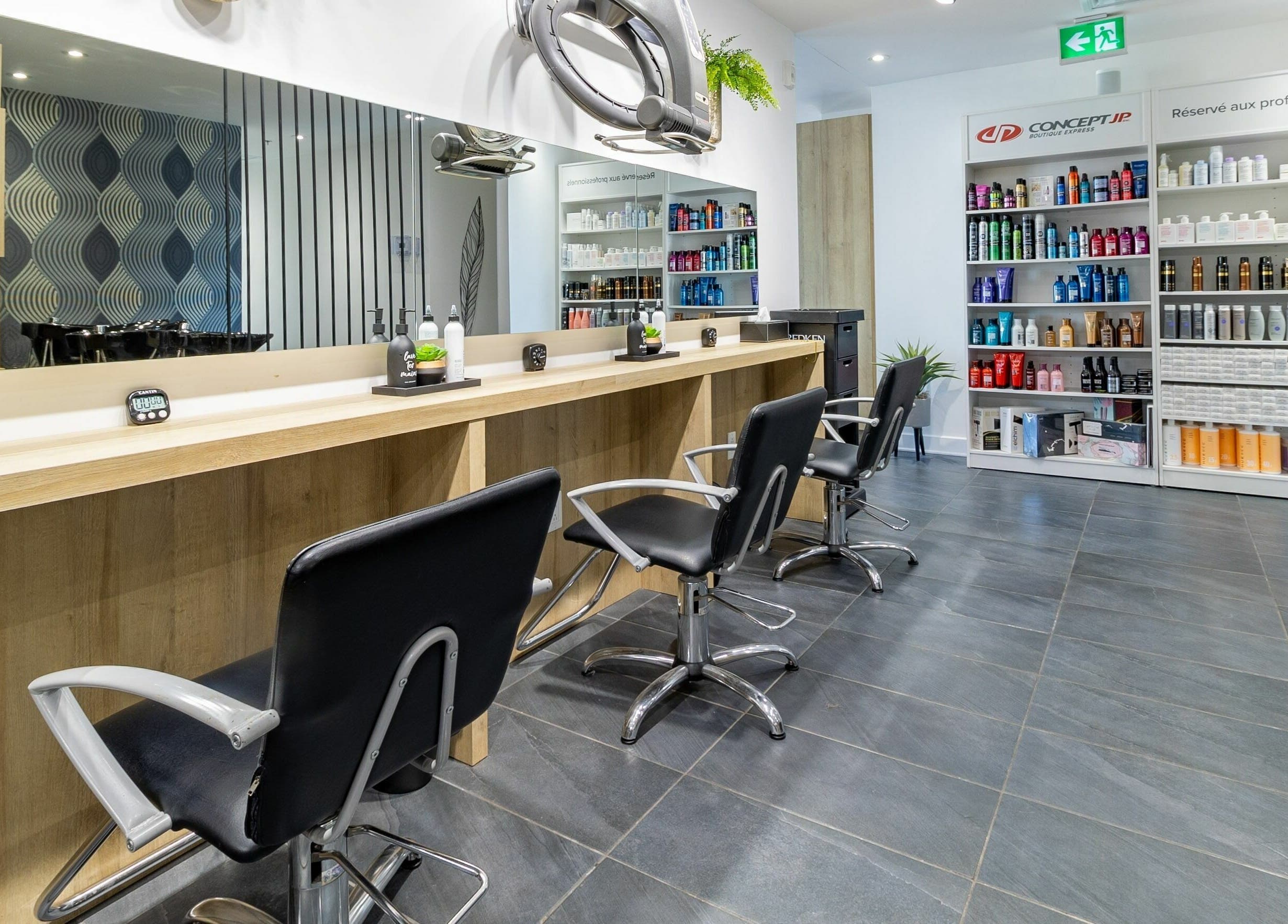 Intérieur moderne de Coiffure Tendance Urbaine à Blainville, Québec, CA, avec des postes de coiffure bien équipés.