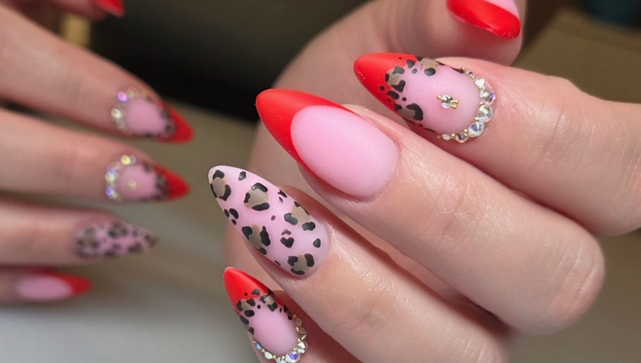 Vibrant nail art at Celeste's Nail Studio in Fairfax, Virginia, US, featuring red and leopard print designs.