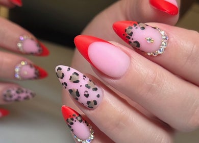 Vibrant nail art at Celeste's Nail Studio in Fairfax, Virginia, US, featuring red and leopard print designs.