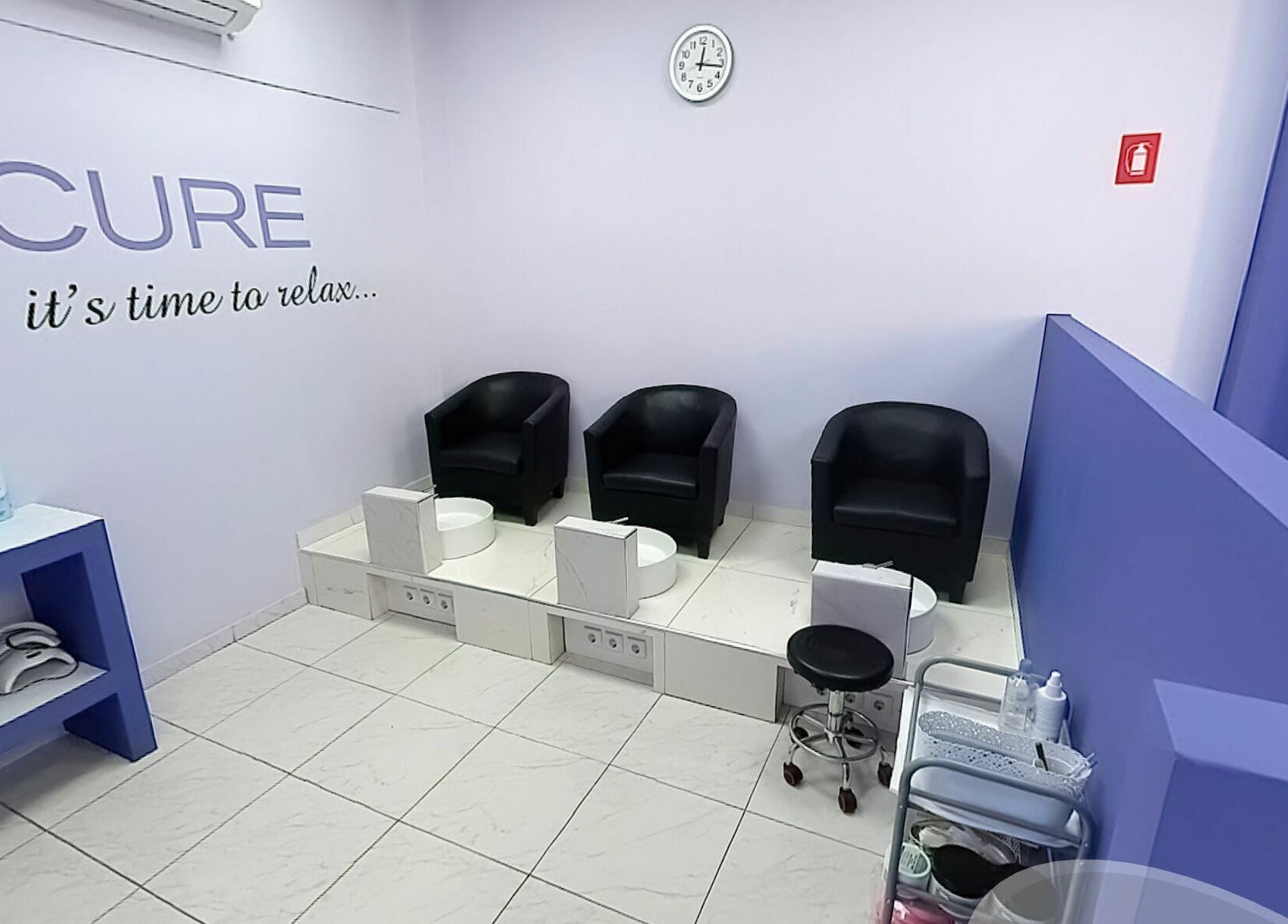 Κομψός χώρος πεντικιούρ στο Nails4you Παγκράτι, Αθήνα, GR με μαύρες πολυθρόνες και μοντέρνα διακόσμηση.