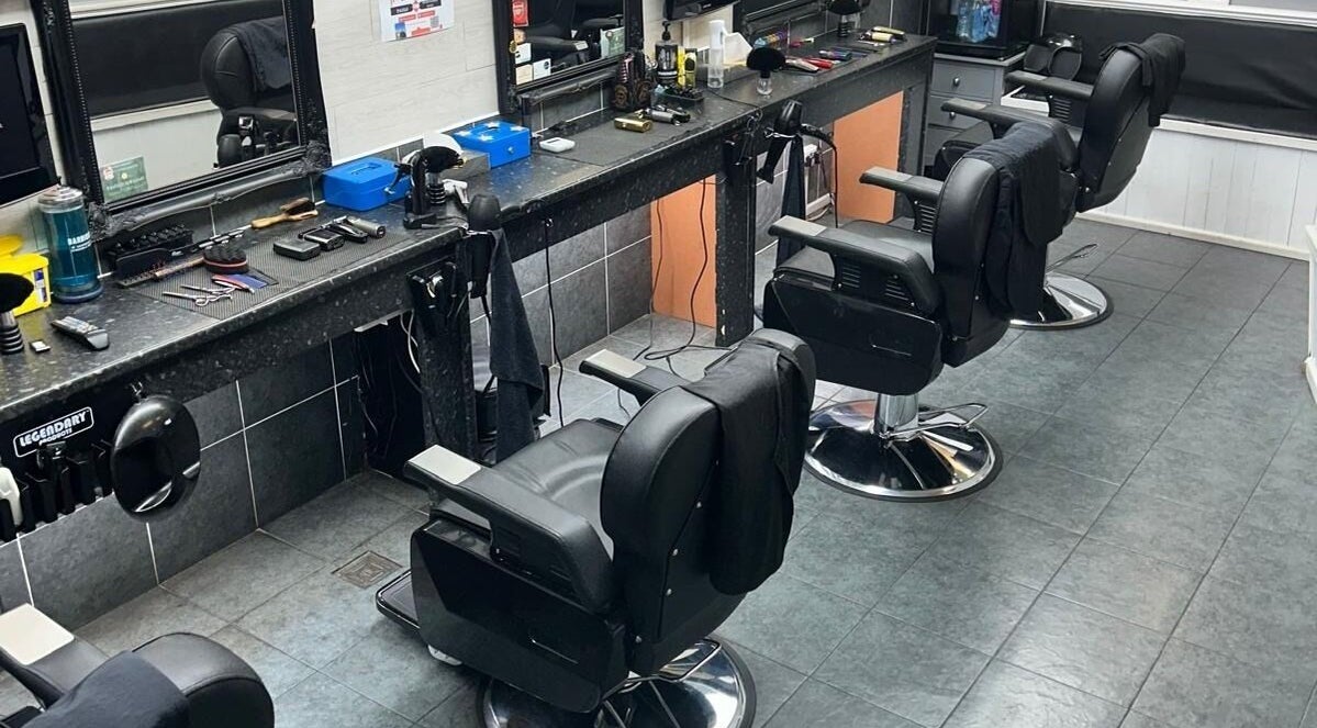 Interior of Pask Gents, a barber shop in Bedford, England, GB, featuring stylish chairs and grooming tools.