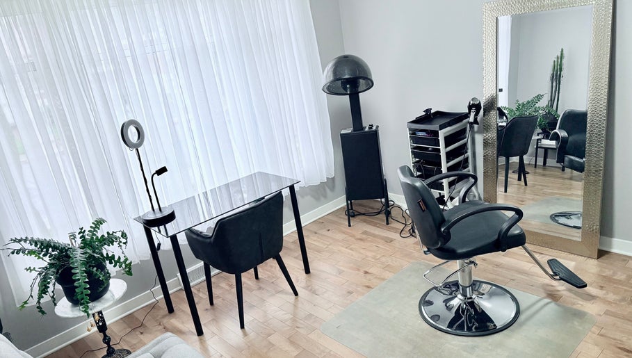 Intérieur élégant de Luc Soucy styliste/coloriste à Longueuil, Québec, CA, avec miroir et fauteuil.