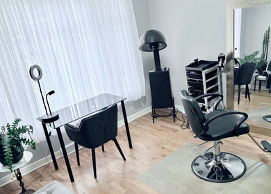 Intérieur élégant de Luc Soucy styliste/coloriste à Longueuil, Québec, CA, avec miroir et fauteuil.