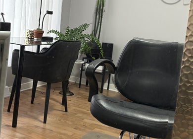 Intérieur élégant de Luc Soucy styliste/coloriste à Longueuil, Québec, CA, avec fauteuil moderne et plantes.