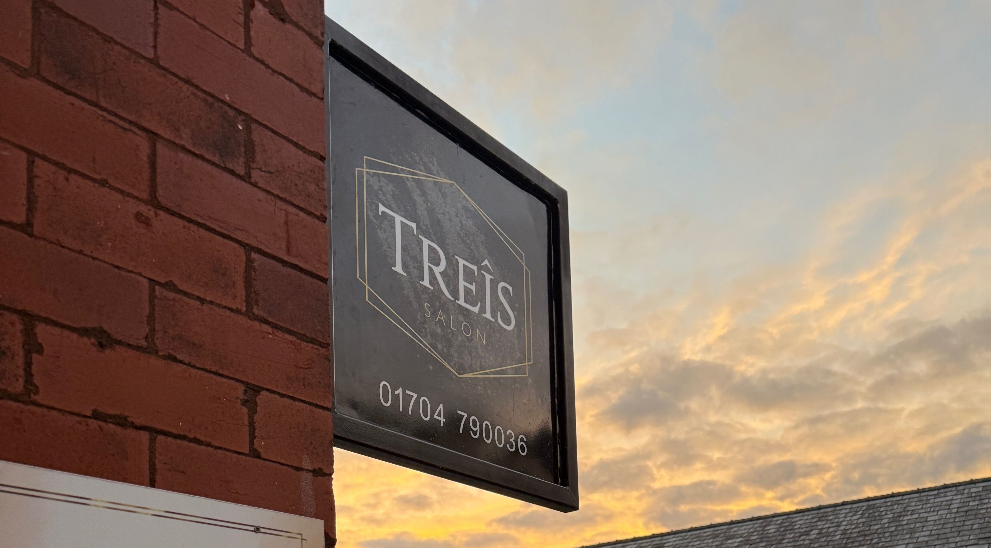 Treîs Salon sign at sunset in Southport, England, GB, showcasing elegant branding.