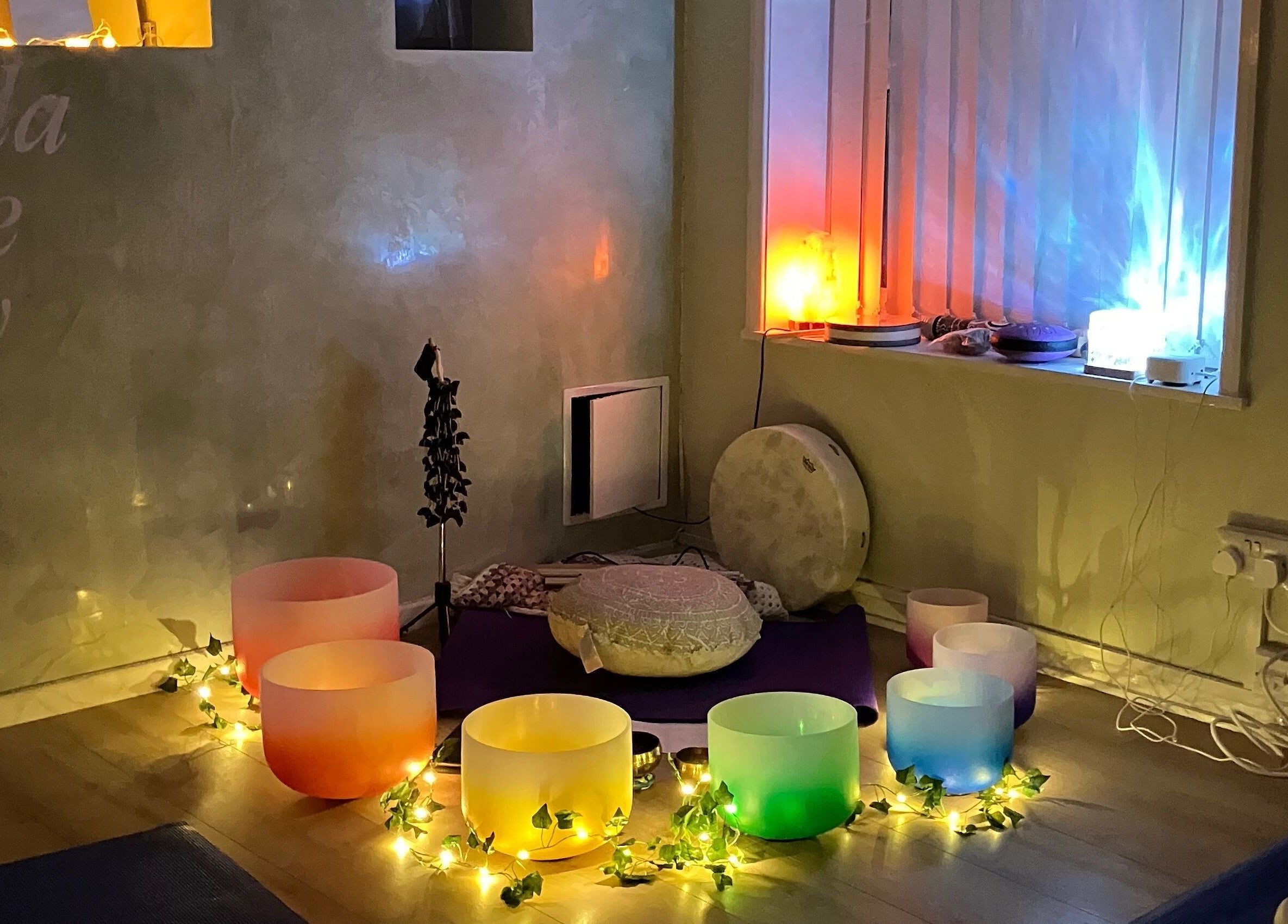 Serene atmosphere at Jacaranda Massage Therapy in Gorleston-on-Sea, England with glowing colored bowls and soft lighting.