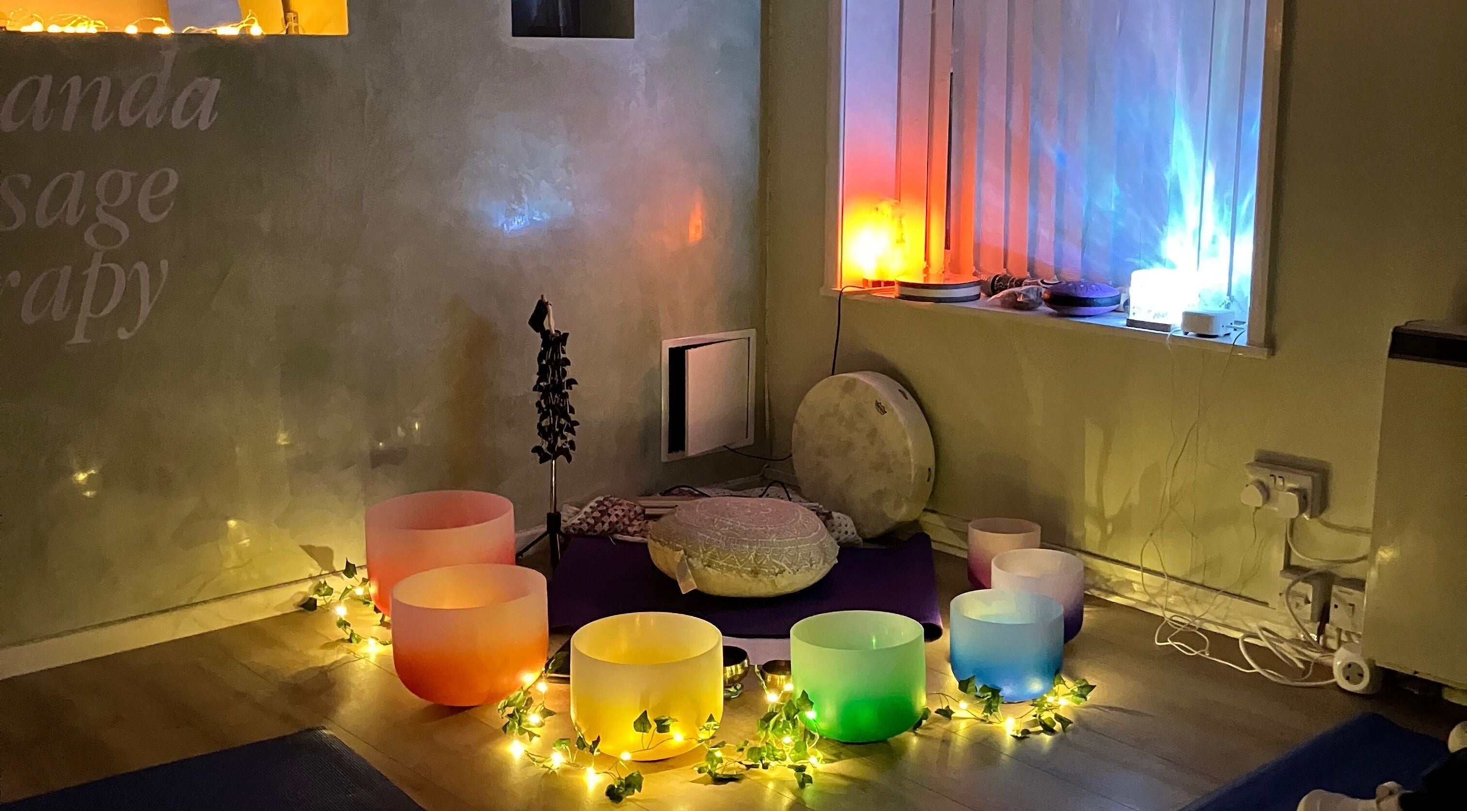 Serene atmosphere at Jacaranda Massage Therapy in Gorleston-on-Sea, England with glowing colored bowls and soft lighting.