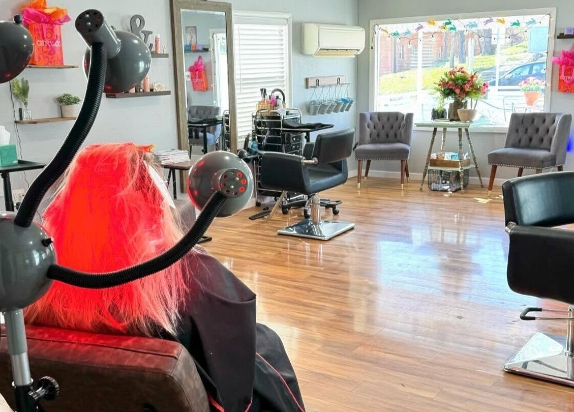 Modern salon at Blend in Branson, Missouri, US with stylist chair and vibrant red hair treatment.
