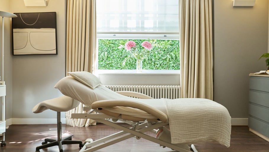 A tranquil treatment room at Wellness at The Laslett, London, England, GB with a massage bed and soft lighting.