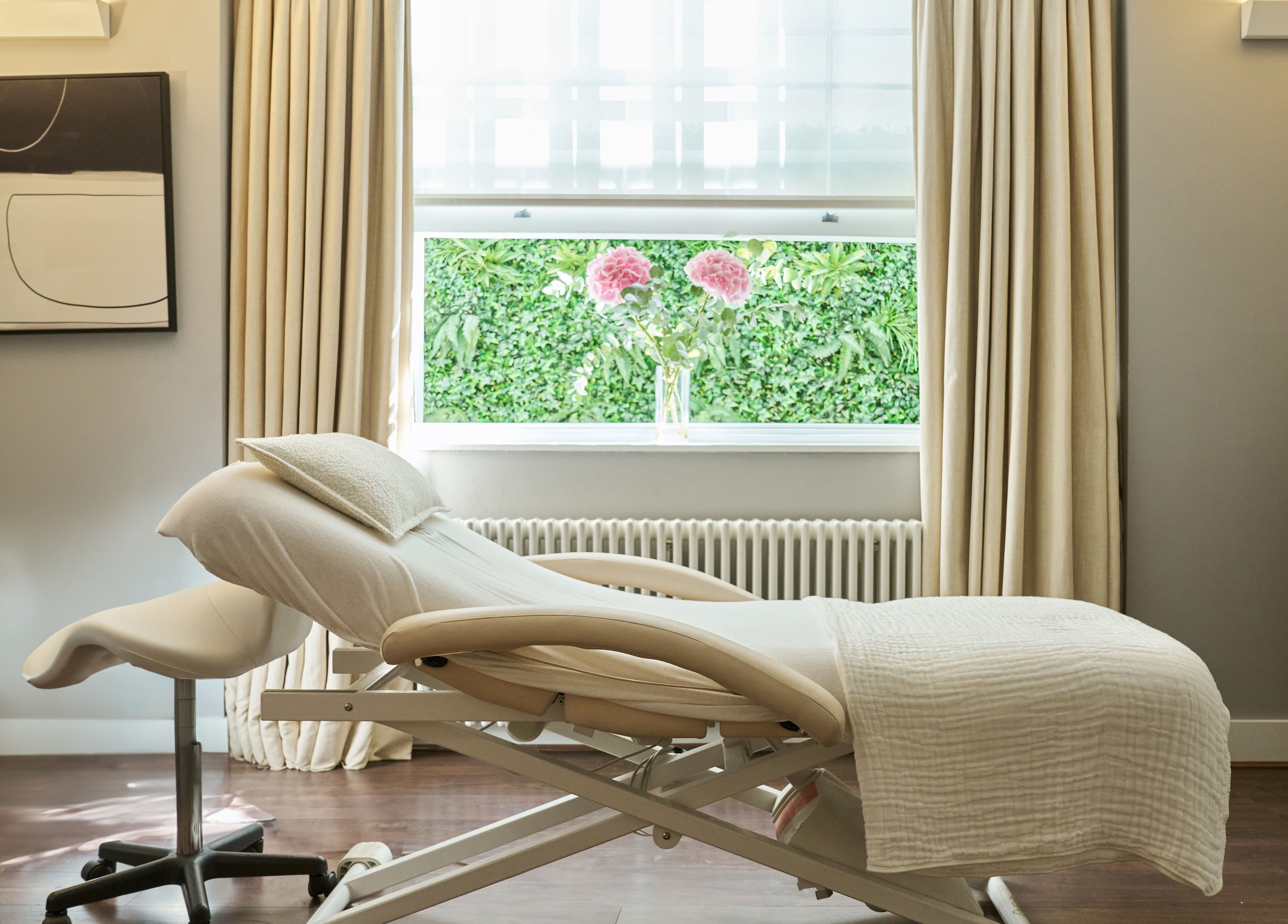 A tranquil treatment room at Wellness at The Laslett, London, England, GB with a massage bed and soft lighting.
