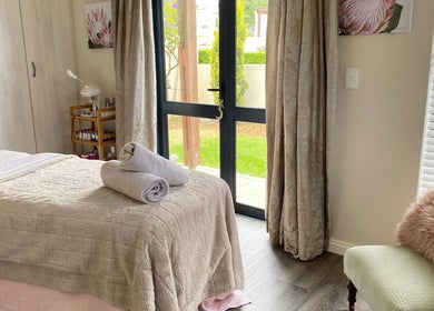 Tranquil spa room at All about Skin Studio, Cape Town, Western Cape, ZA, featuring plush bedding and natural light.