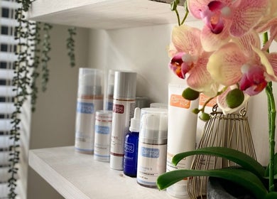 Beauty products and orchids at All about Skin Studio, Cape Town, Western Cape, ZA enhance a serene atmosphere.