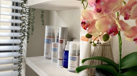 Beauty products and orchids at All about Skin Studio, Cape Town, Western Cape, ZA enhance a serene atmosphere.