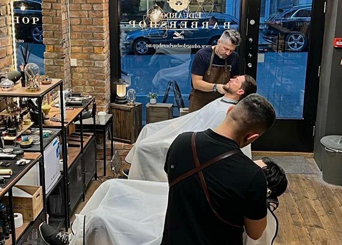 Moderne interiør hos Eduardo’s barbershop AS Avd. Frogner i Oslo, Oslo, NO med kunder i barberstoler.