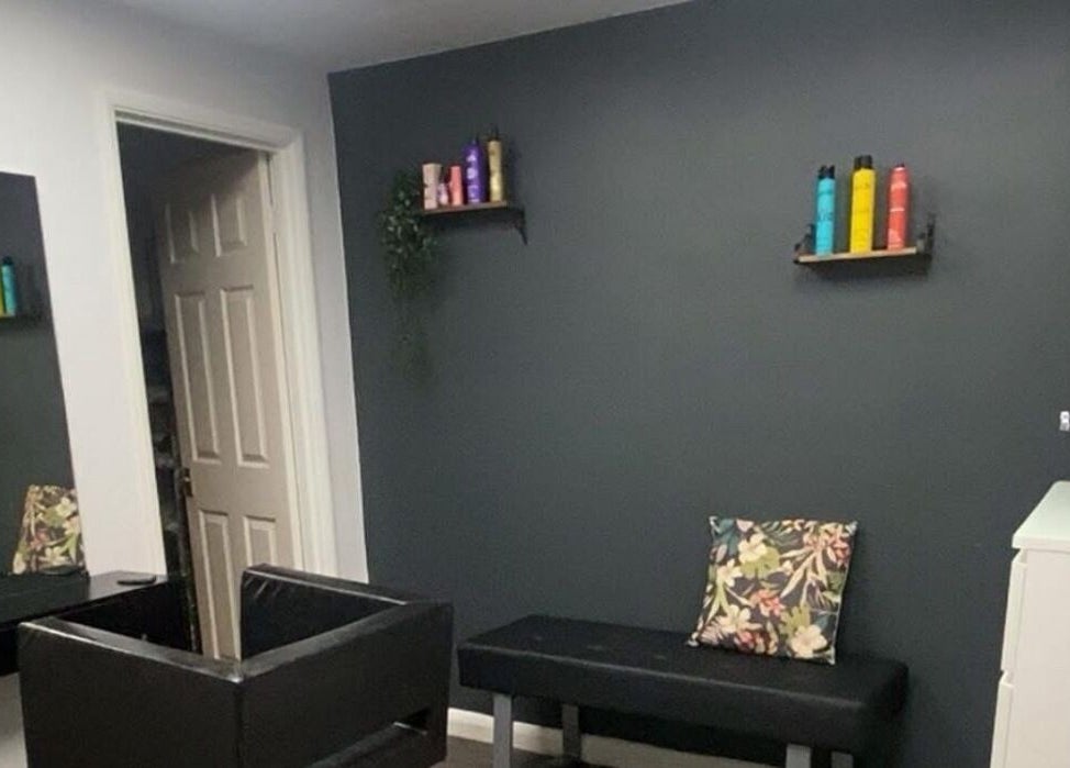 Stylish interior of Head to Toe in Grassmoor, England, GB with dark walls and modern furniture.