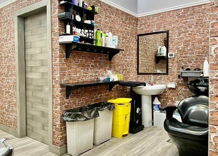 Brick-walled interior of Vintage Men's SPA - Al Wahada Mall, Abu Dhabi, featuring salon chair and sink.