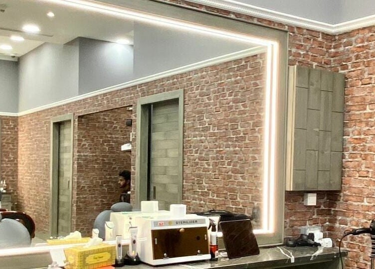 Chic interior of Vintage Men's SPA - Al Wahada Mall, Abu Dhabi with brick walls and modern styling tools.