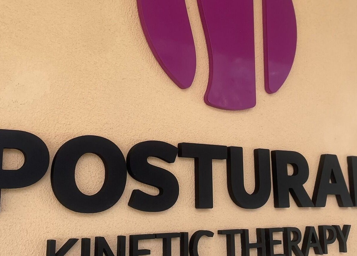 Logo vibrant Postural Kinetic Therapy, București, Romania, RO pe perete crem.