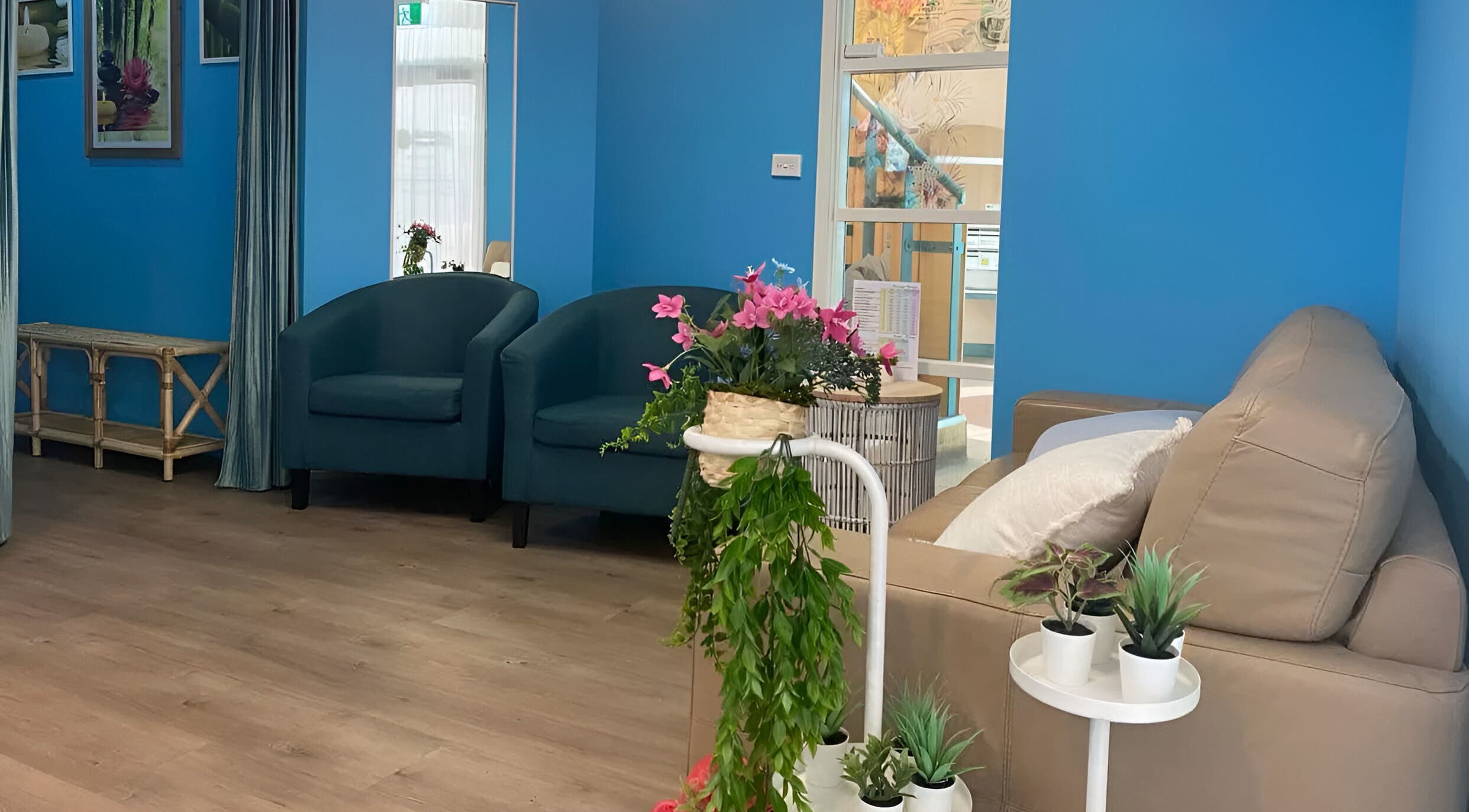 Relaxing lounge area at Thai Unique Massage at Dickson, featuring plush seating and vibrant plants, Dickson, AU.