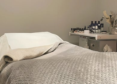 Cozy massage bed at Blissful Beauty and Massage Therapy, Glastonbury, England, GB, surrounded by essential oils.