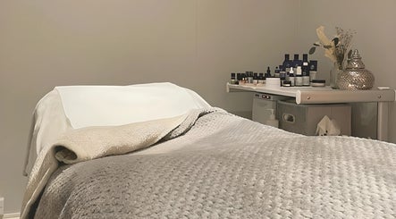 Cozy massage bed at Blissful Beauty and Massage Therapy, Glastonbury, England, GB, surrounded by essential oils.