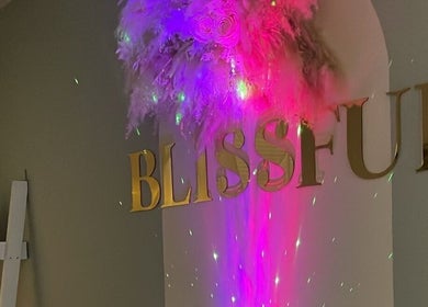 Colorful lights illuminate 'Blissful' sign at Blissful Beauty and Massage Therapy in Glastonbury, England, GB.