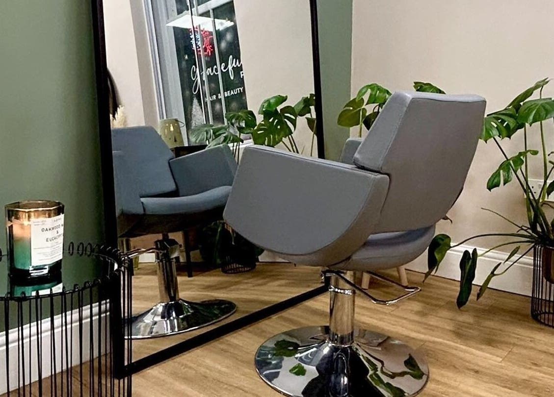Graceful salon interior with chic chair and lush plants in Glossop, England, GB.