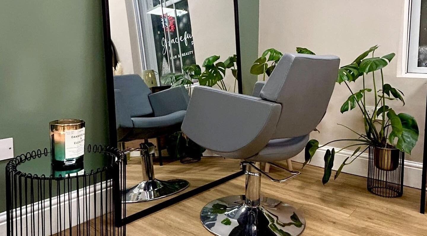 Graceful salon interior with chic chair and lush plants in Glossop, England, GB.