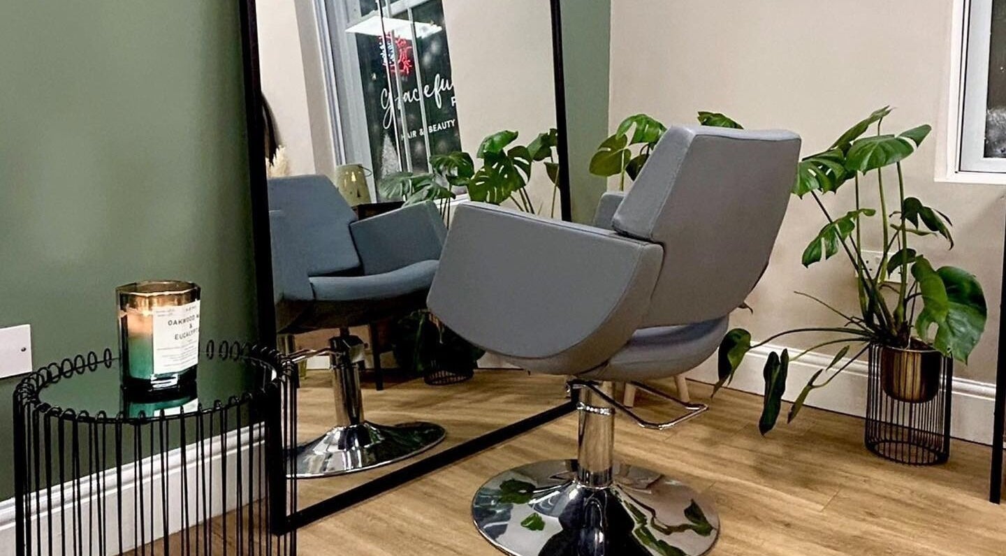 Graceful salon interior with chic chair and lush plants in Glossop, England, GB.