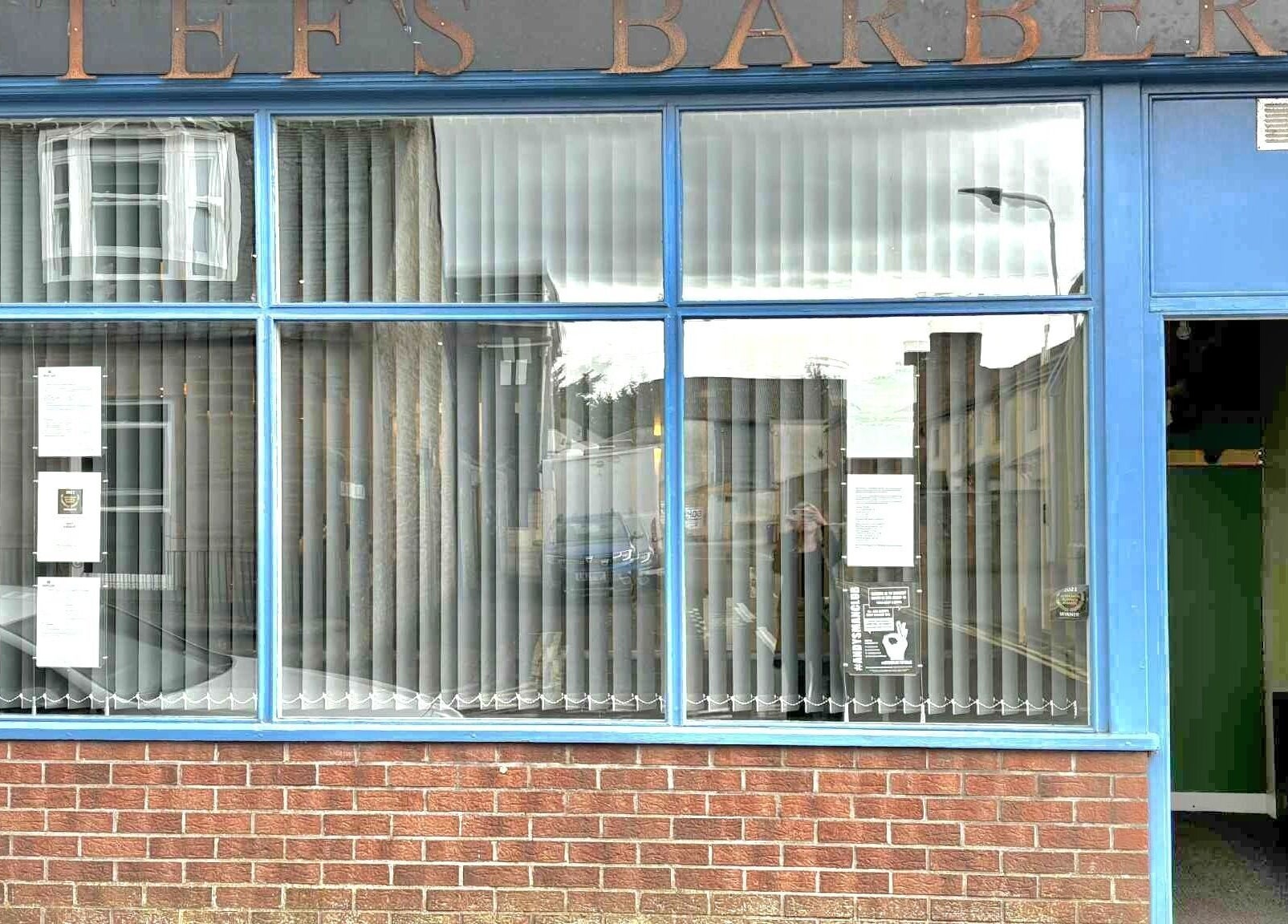 Stefs barber's Forfar entrance in Forfar, Scotland, GB with blue door and large windows.