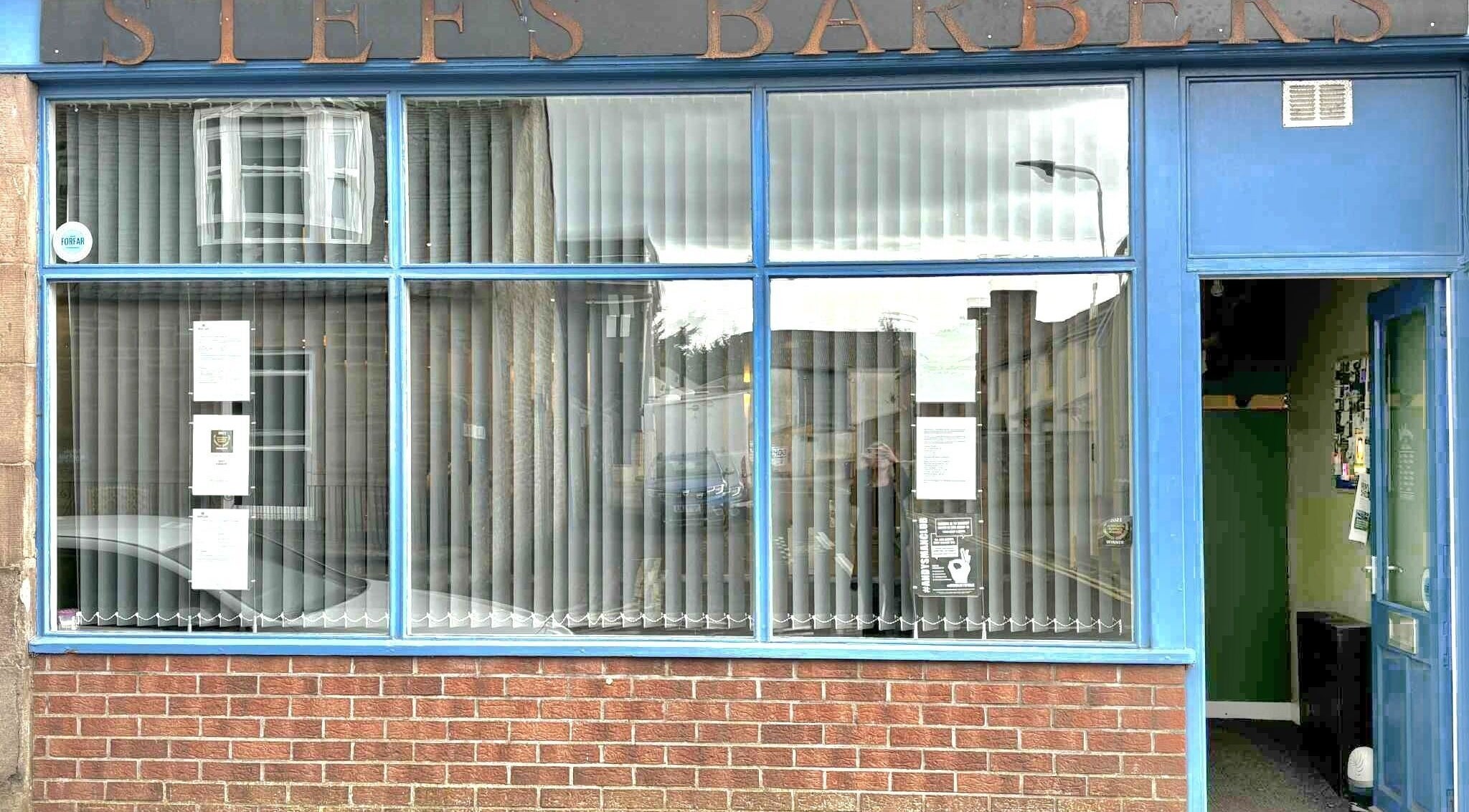 Stefs barber's Forfar entrance in Forfar, Scotland, GB with blue door and large windows.