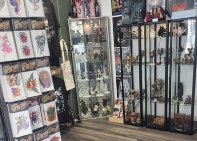 Kracken Body Art tattoo displays at Gorleston-on-Sea, England, showcasing diverse tattoo flash sheets and collectibles.