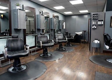 Modern salon interior at Cuts ‘N’ Clippers Refinery Rooms in Horley, England, GB with sleek barber chairs and mirrors.